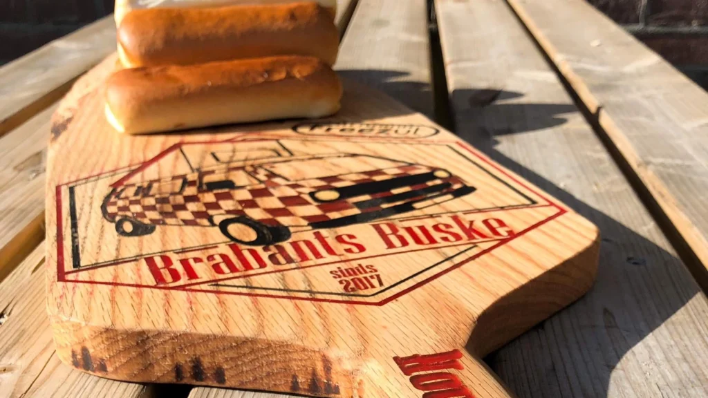 Plank met worstenbroodjes en logo op maat gemaakt voor het Brabants Buske
