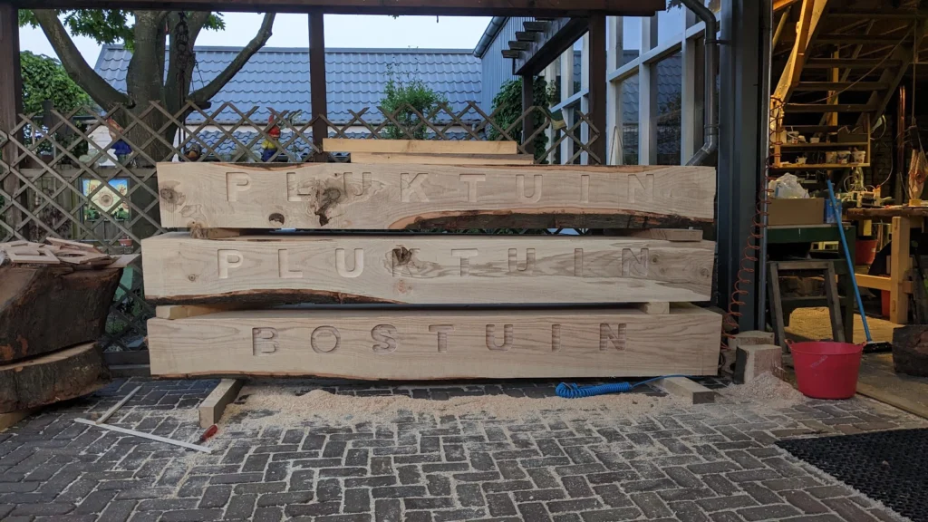 Tekst in hout gefreesd